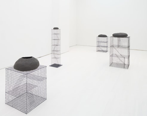 Gallery installation view of several black ceramic pieces