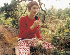 Photo of woman in nature holding microphone 