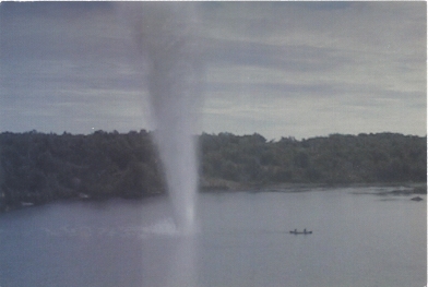 Image of tornado over lake, with people in canoe rowing away