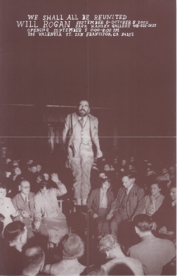 Image of man standing on chair amongst larger seated crowd