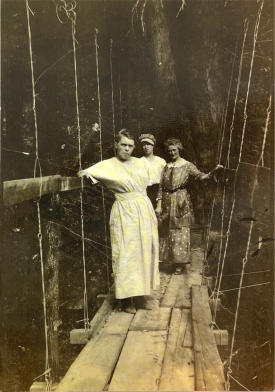 Old photo of three woman standing on wooden walkway