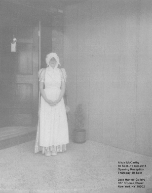 Black and white image of woman standing before home