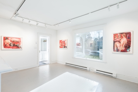 Installation view of red hued paintings featuring women