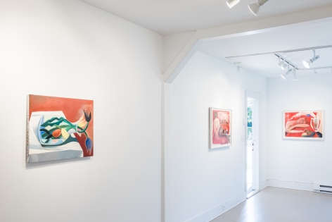 Installation view of red hued paintings featuring women