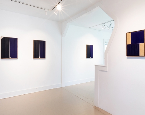 Install view of several blue and black abstract works