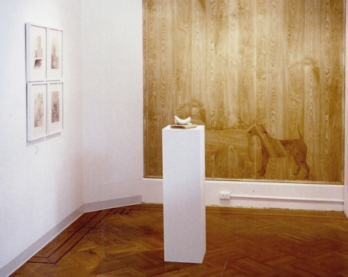 Large wooden work showing two dogs, installation view