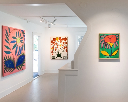 Gallery installation view of paintings featuring anthropomorphic plants